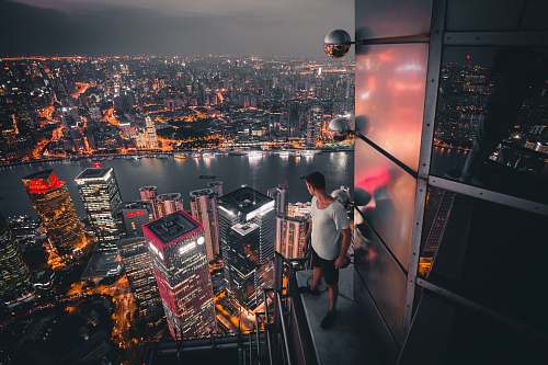 landscape man standing at buildings rooftop overlooking city nature