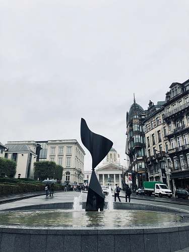building outdoor fountain under white sky downtown