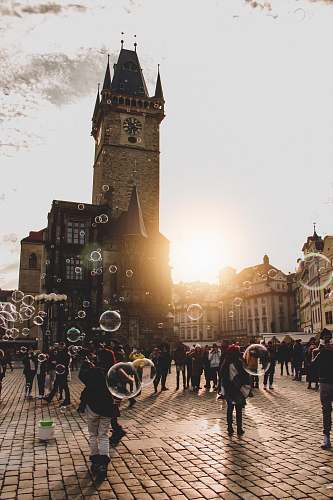town people gathering outdoor with bubbles during daytime building