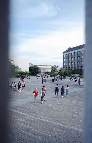 building people walking on ground during daytime downtown