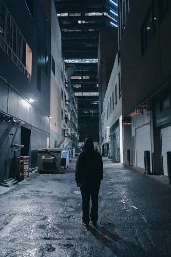 building person in a alley during nighttime with lights road