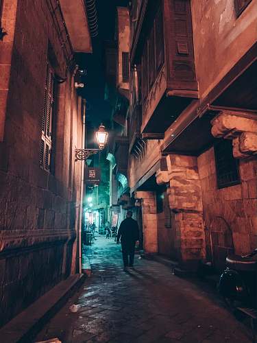 road person walking near alley during nighttime building