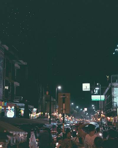 building photography of people gathering near outdoor during nighttime metropolis
