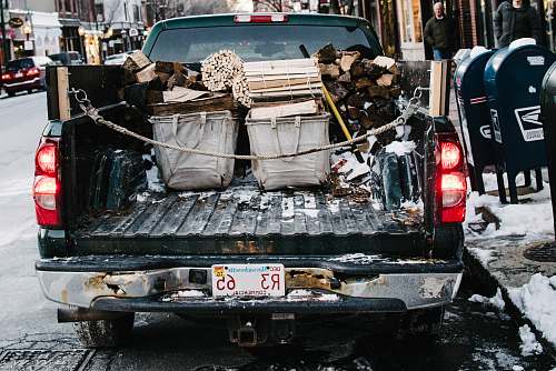 vehicle pickup truck loaded by firewood while parked on concrete roadway boston