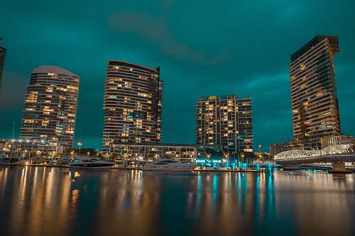 building powerboats in body of water near buildings high rise