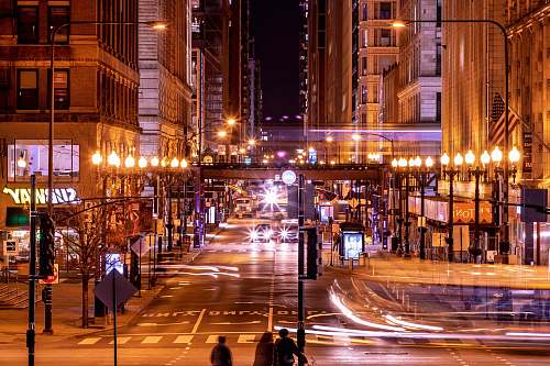 urban time-lapse photography of lighted buildings at night road