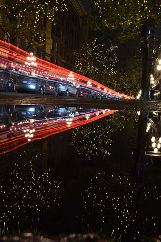building timelapse photography of vehicles on road at night metropolis