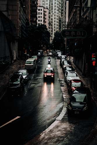 building vehicles on road between buildings close-up photography metropolis