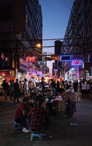 pedestrian people walking on street between buildings person