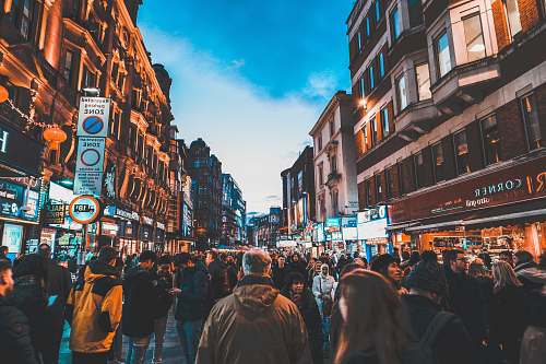 pedestrian people walking on street between commercial buildings person