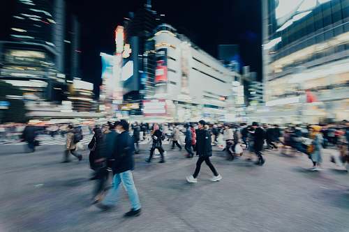 pedestrian people walking on street near buildings during nighttime person