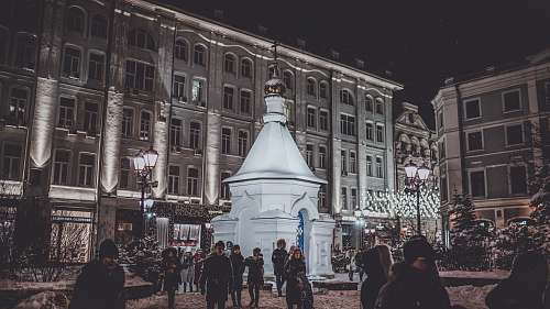 pedestrian people walking outside near white dome building during nighttime person