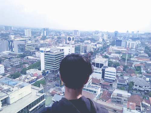 nature man standing at rooftop overlooking city outdoors