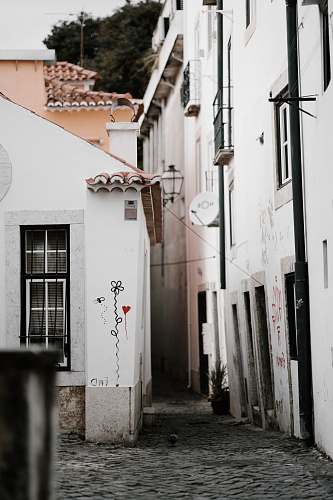 city white parabolic antenna on building wall during daytime street
