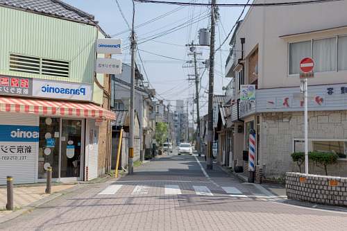 street white car traveling on street approaching intersection town