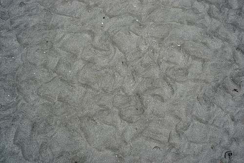 grey person in blue denim jeans standing on gray sand concrete