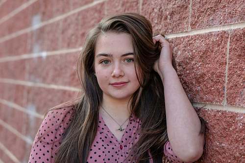 human woman in pink and black polka dot shirt brick