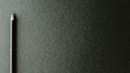grey black pencil on black surface word
