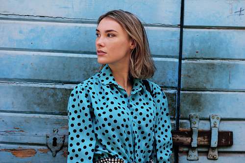 human shallow focus photo of teal and black polka-dot long-sleeved shirt person