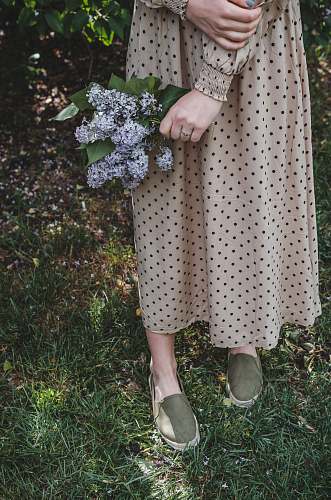 apparel woman in white and black polka dot dress and white shoes standing on green grass field clothing