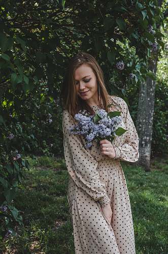 apparel woman in white and black polka dot dress standing on green grass field clothing