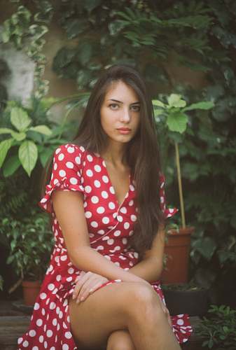 human woman sitting in front of leafed plants person