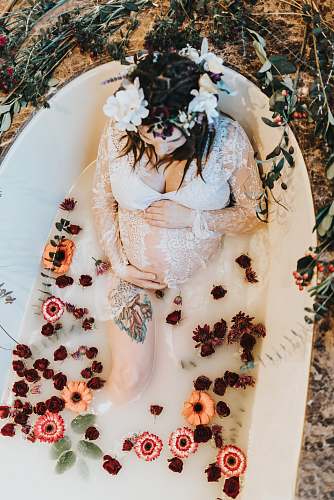 clothing pregnant woman on bathtub covered with white liquid dessert