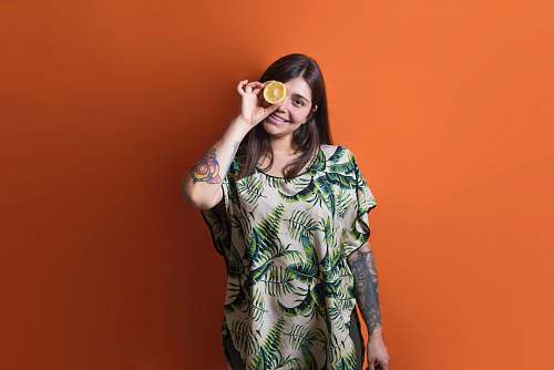 clothing woman putting sliced lemon on eye dress