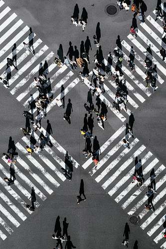 tarmac aerial view of people walking on cross pedestrian lane road