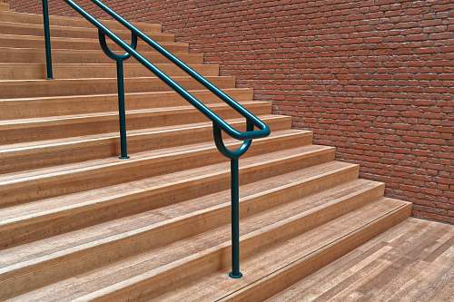 handrail brown concrete staircase with green metal railing staircase