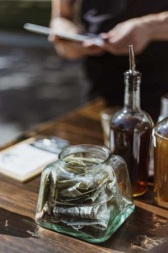 drink banknotes in clear glass container on wooden surface liquor
