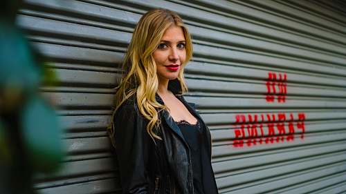 female woman standing in front of grey shutter door woman