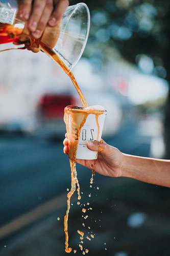 coffee person holding white ZOE brand paper cup drink