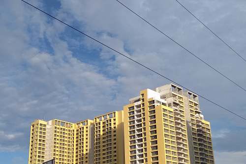 city beige multi-story building under cloudy sky high rise