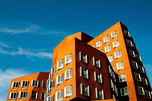condo brown concrete building under cloudy sky housing