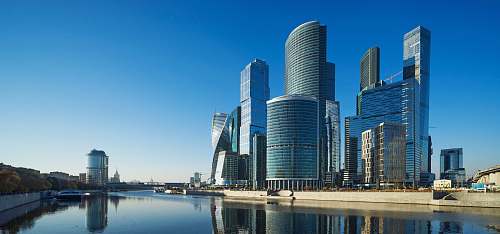 town cityscape near body of water under blue sky high rise