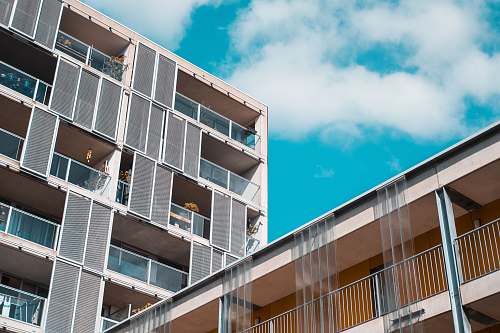 city gray concrete building under cloudy sky high rise