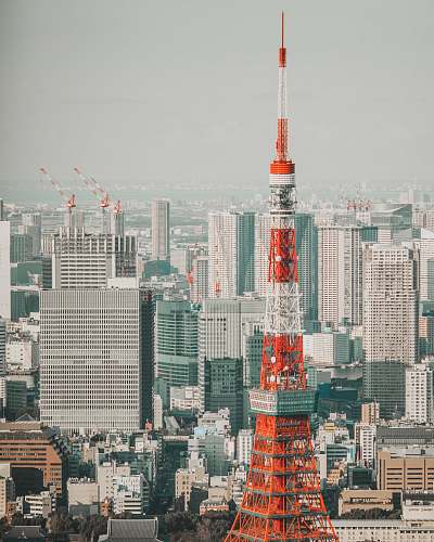 city selective photography of orange and white tower surrounded by city buildings urban