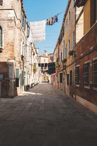path textiles hanging near houses during daytime walkway