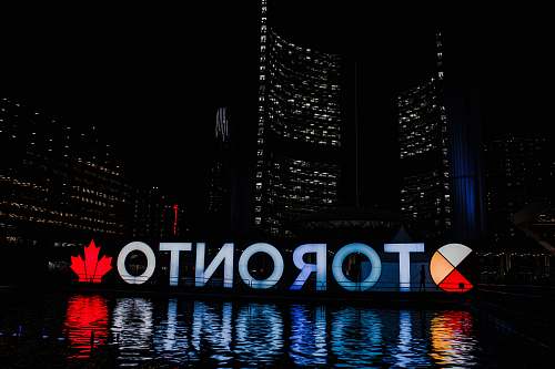 city Toronto sign reflecting on body of water at night metropolis