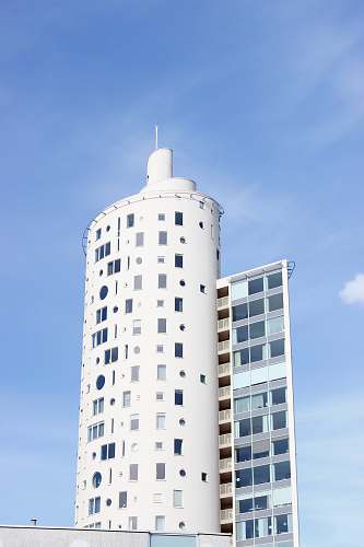 condo white tower building under blue and white sky during daytime housing