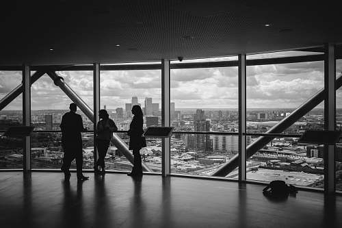 black-and-white people standing inside city building skyline
