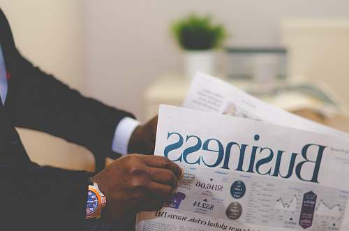 finance person wearing suit reading business newspaper newspaper