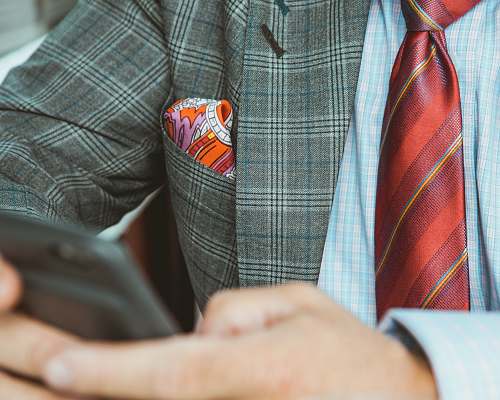 fashion selective focus photography of person holding black smartphone business man