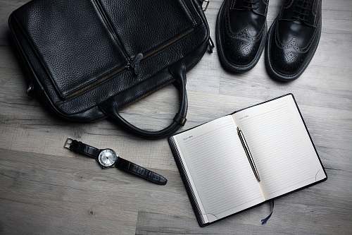 shoe white notebook near black bag bag