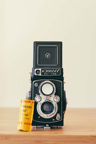 electronics gray and black Yashica camera on brown surface vintage