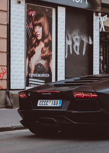 human black Lamborghini beside Kevin Murphy poster person