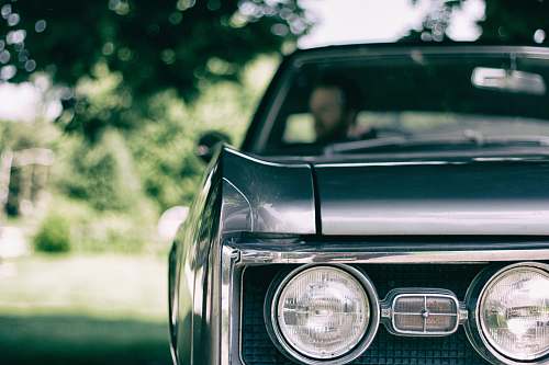 headlight man inside black muscle car automobile