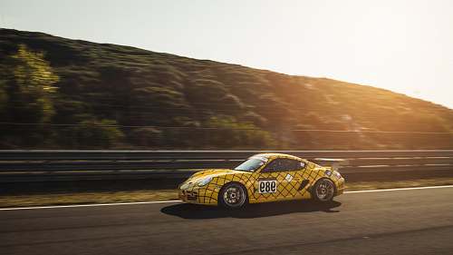 automobile panning photo of yellow car running on road transportation