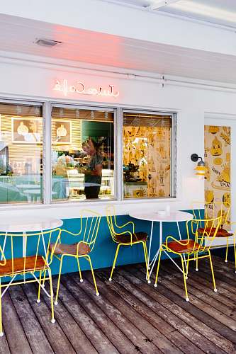 furniture two round white metal tables with chairs beside wall cafe
